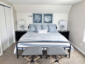 A bedroom with a bed, bedside tables, and artwork on the wall. - Waterfront Private Beach byCountry Road Properties (Lower Township)