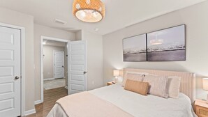 A bedroom with a bed, bedside tables, a hanging light fixture, and a wall-mounted artwork. - Family-Friendly Retreat Near Gulf Shores, Beach (Foley)