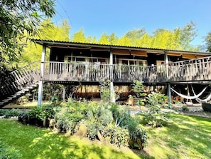 Eine Holzhütte mit überdachter Veranda und Garten.
