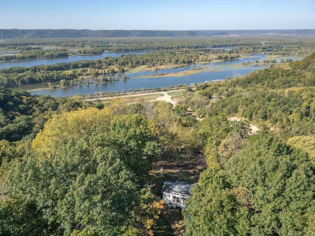 A large house surrounded by dense forest and multiple lakes.