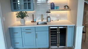 A kitchen with light blue cabinets, a built-in oven, and a countertop with a blender and a potted plant. - Brand New! Enjoyable 5-bedroom house with AC in Wells Beach (Wells)