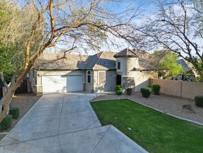 A residential house with a garage, a stone facade, and a well-maintained lawn.
