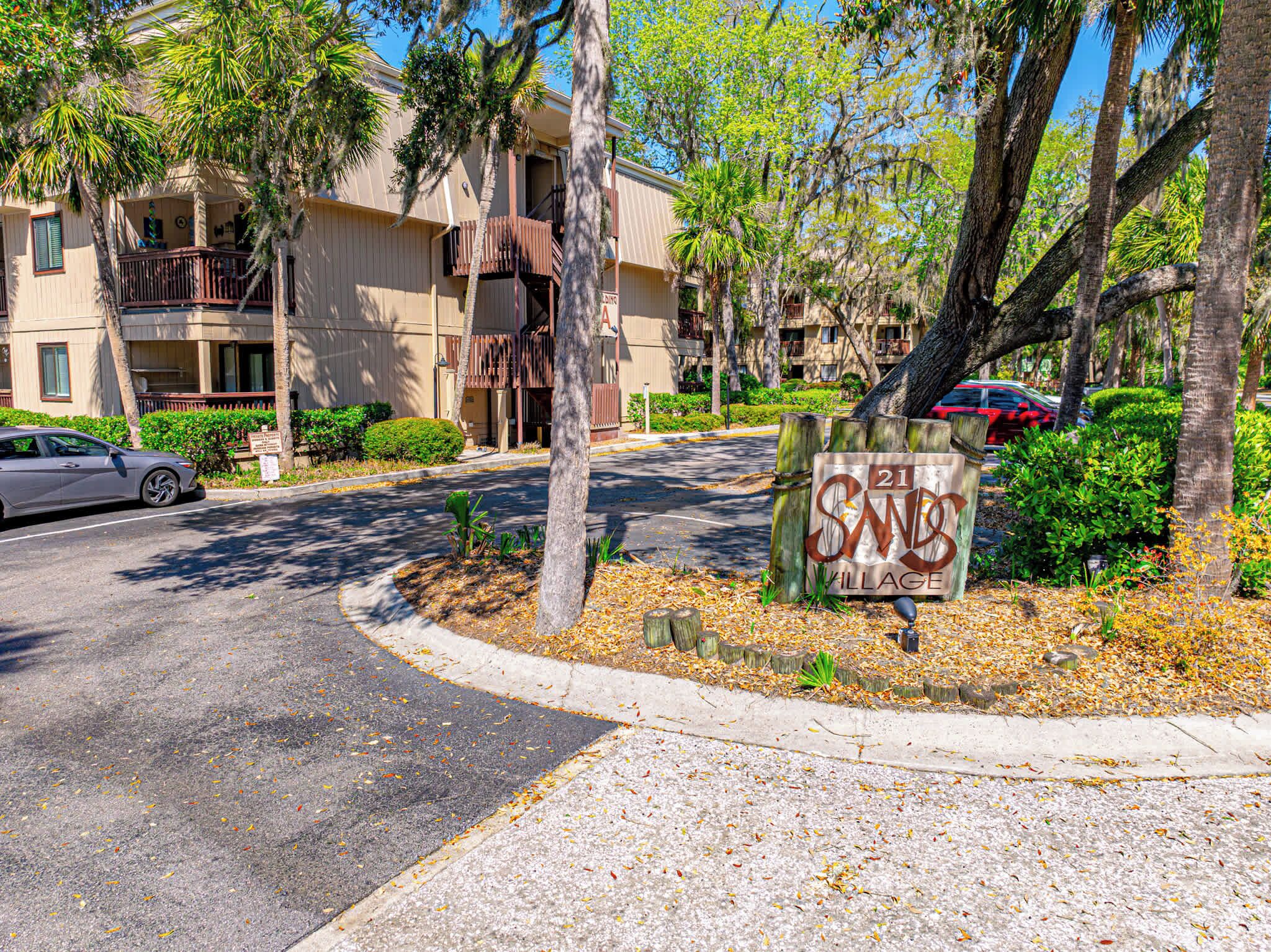 A residential area with a sign for '21 Sands Village.'