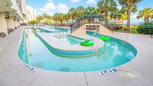 Uma área de piscina com duas piscinas, palmeiras e uma escadaria que leva a um deck.