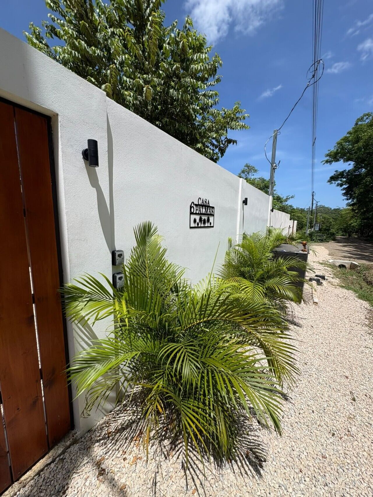 Pared blanca con una puerta y un letrero que dice 'Casa 6 Parais'.