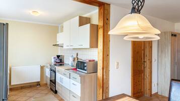 A kitchen with white cabinets, a microwave, and a wooden door.