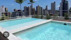 A rooftop pool with a city skyline in the background. - Flat Aconchegante em João Pessoa (João Pessoa)