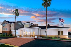 A hotel with a modern architectural design, featuring a prominent sign for "Homewood Suites." - Homewood Suites By Hilton Corpus Christi Downtown (Corpus Christi)