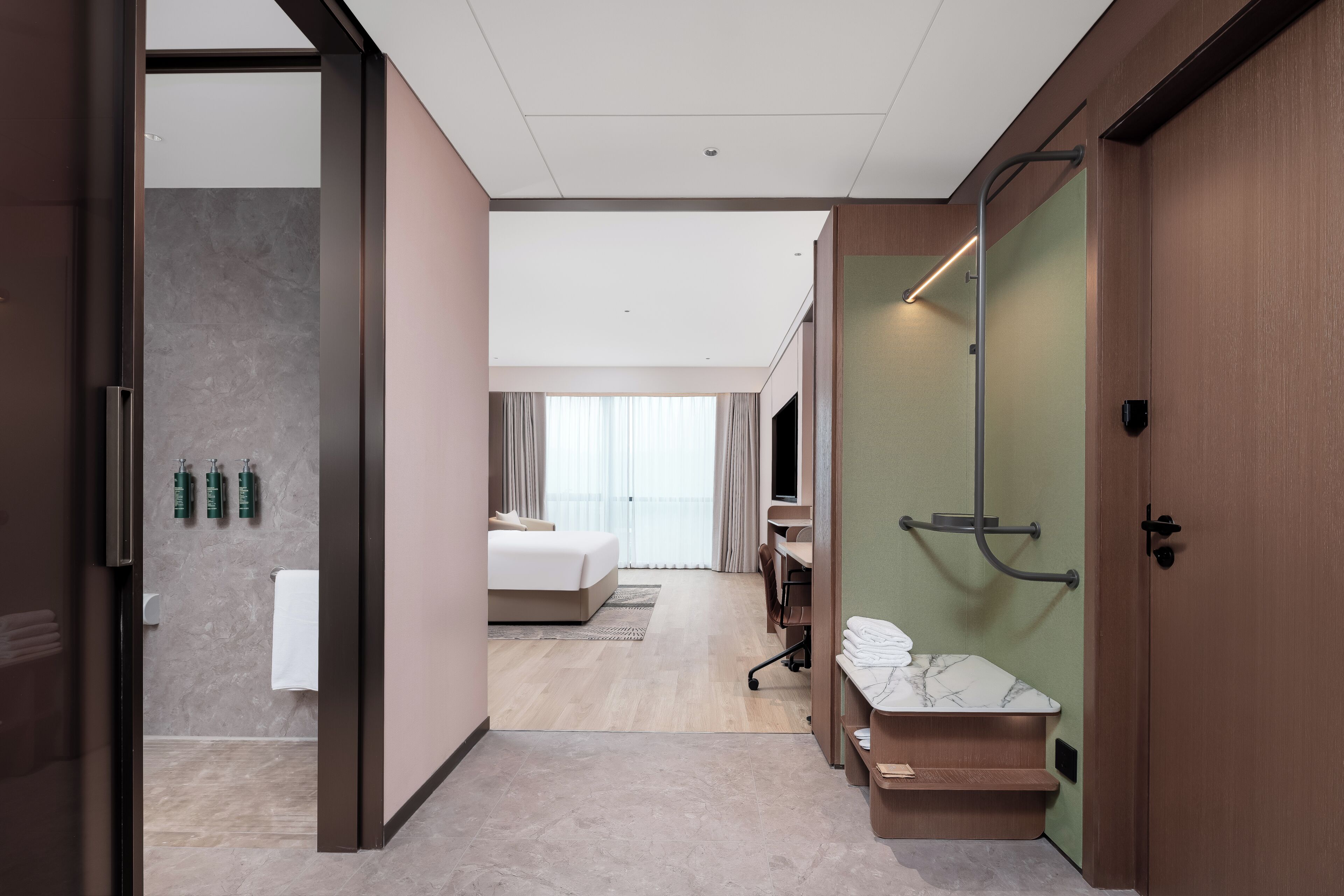 Ein modernes Hotelzimmer mit Bett, einem Badezimmer mit Dusche und einer Sitzecke.