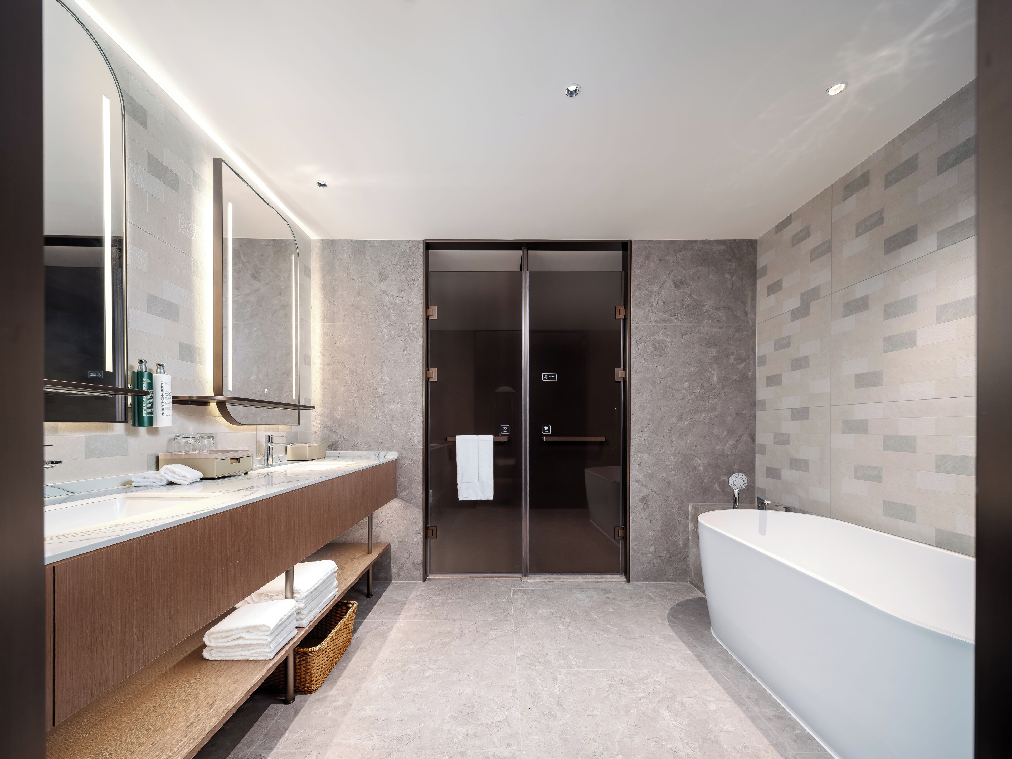 A modern bathroom with a large bathtub, a vanity with a mirror, and a shower area.