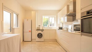 Una cocina moderna con lavadora incorporada, refrigerador y microondas.