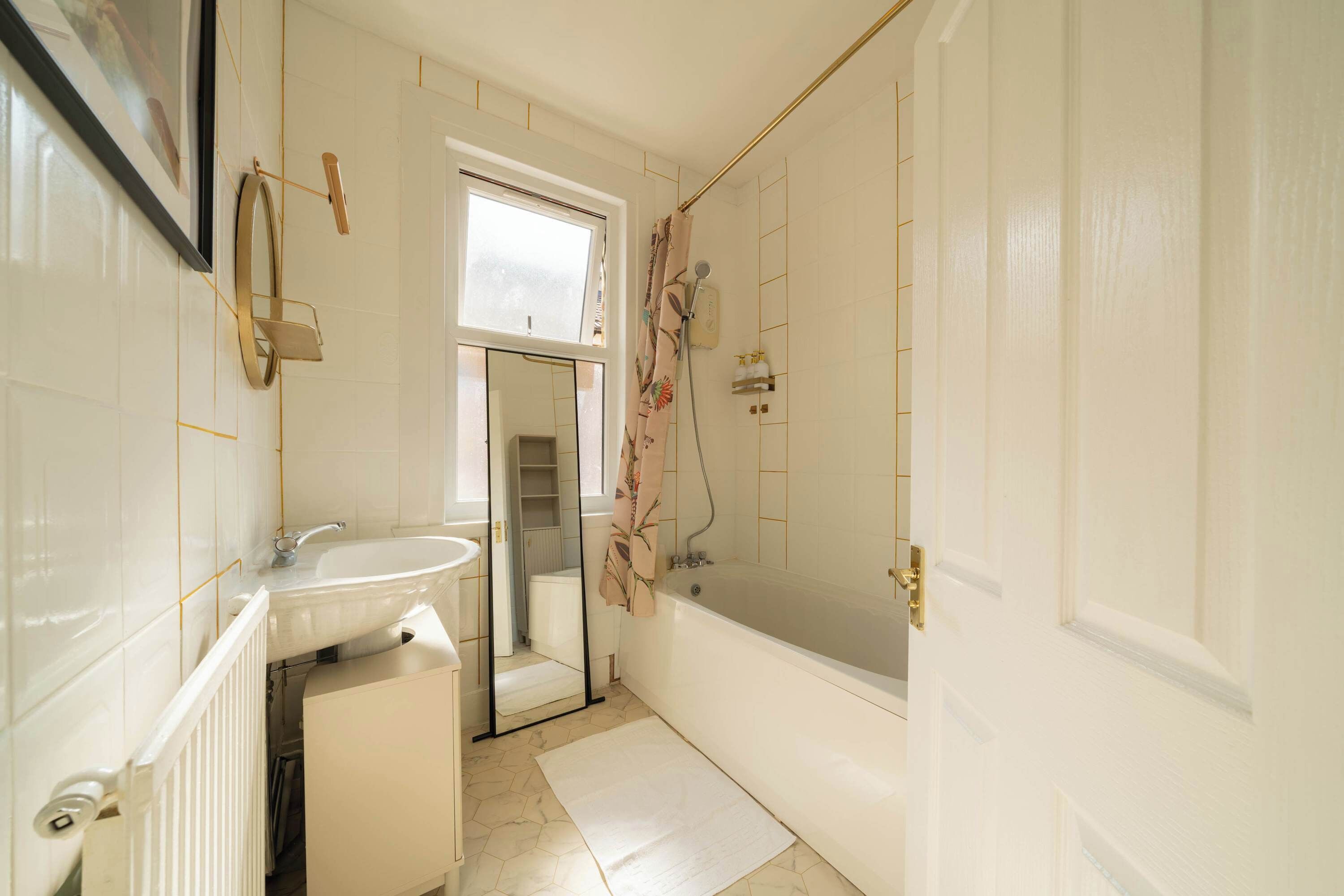 A bathroom with a white sink, a bathtub, and a shower area.