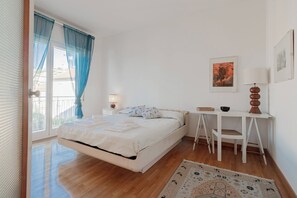 A bedroom with a bed, a desk, a chair, a lamp, and a painting on the wall. - CASA MEDITERRANEA - Vista Mare - Parcheggio (Sanremo)