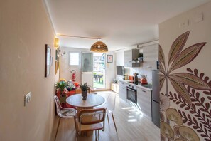A modern kitchen with a dining area, a fire extinguisher, and a large window. - LA TERRAZZA SUL MARE - Sanremo (Sanremo)