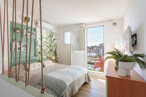 A bedroom with a bed, a hanging chair, a balcony with a view, and a potted plant. - LA TERRAZZA SUL MARE - Sanremo (Sanremo)