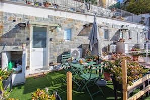 A stone building with a patio area, outdoor seating, and potted plants. - LA TERRAZZA SUL MARE - Sanremo (Sanremo)