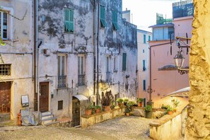 A narrow street with buildings, a fire hydrant, and potted plants. - LA TERRAZZA SUL MARE - Sanremo (Sanremo)