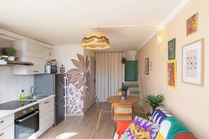 Una cocina moderna con comedor, un sofá y una escalera que lleva a otro nivel.
