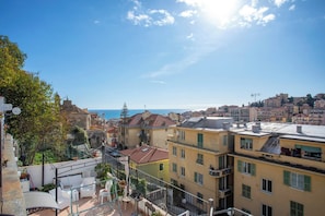Un paisaje urbano costero con edificios, cielo despejado y el mar al fondo.