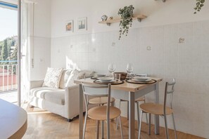 A dining area with a table set for four, a sofa, and a balcony view. - CASA ARMONIA - Vista Mare - Sanremo (Sanremo)