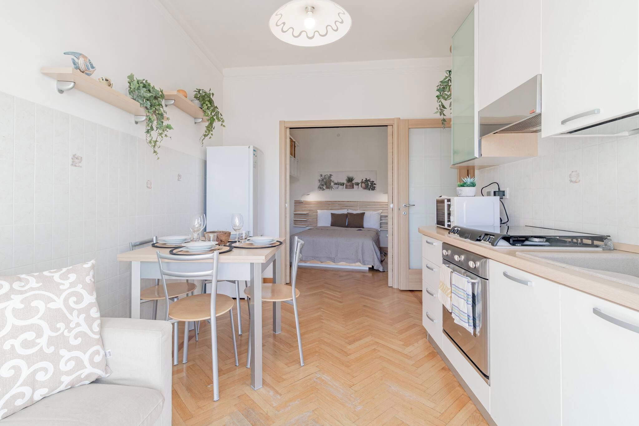 Une cuisine compacte avec un coin repas, un lit et un petit espace de vie.