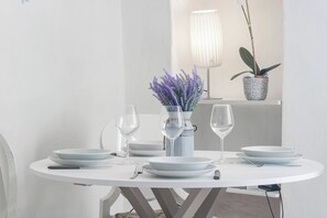 A round dining table with white plates, clear wine glasses, and a vase with purple flowers. - SEA LOFT - Vista Mare - Sanremo (Sanremo)