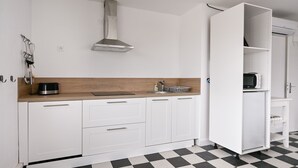 Eine moderne Küche mit weißen Schränken, einem schwarz-weißen Schachbrettboden und einem eingebauten Backofen.