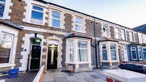 A row of terraced houses with distinct architectural styles, including a bay window and a small turret. - Modern 2BR Flat Steps from Cardiff Pubs & Town (Cardiff)