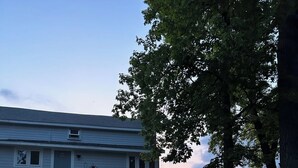 A two-story house with a stone staircase leading to the front door. - Tranquil Lake Michigan 3-bedroom house perfect for a relaxing stay (Mears)