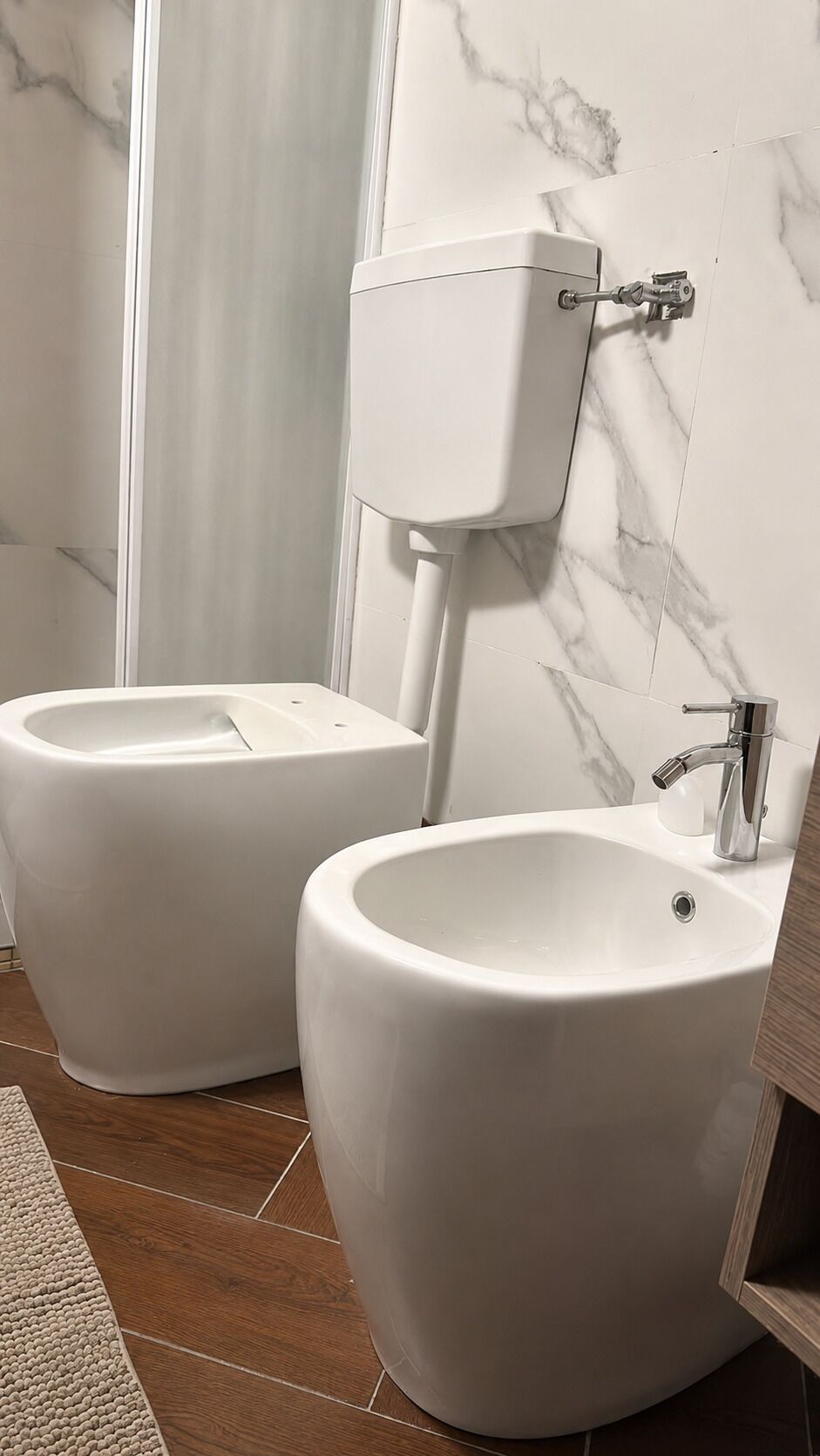 A bathroom with a toilet, bidet, and sink.