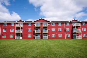 A red multi-story building with balconies and windows.
