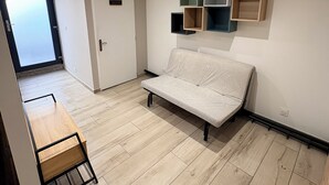 Ein modernes, minimalistisches Zimmer mit einer Couch, einem Holztisch und integrierten Regalen.