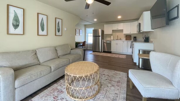 A modern living room with a sofa, a round coffee table, and a ceiling fan. - 4 Bedrooms ~ Clean & Comfortable! (Plattsburgh)