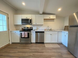 Fridge, dishwasher, coffee/tea maker, cookware/dishes/utensils
