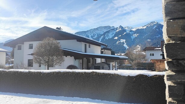 A snow-covered landscape with a house and mountains in the background. - Quiet vacation apartment with terrace and garden - wellness use included. (Reutte)