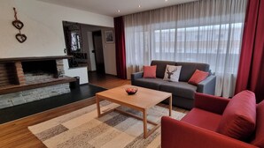 A modern living room with a fireplace, a sofa set, and a coffee table. - Quiet vacation apartment with terrace and garden - wellness use included. (Reutte)