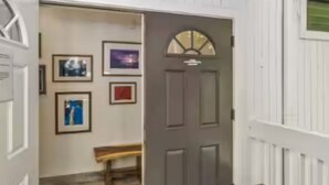 A hallway with a door, framed pictures on the wall, and a bench. - Sacred Jungle Hideaway Surf Villa with AC (Princeville)