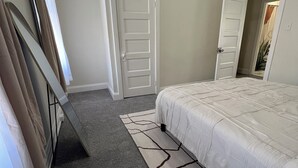 Une chambre à coucher avec un lit, une porte et un tapis.
