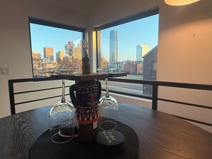 A table with a bottle of Tito's Handmade Vodka, two glasses, and a coaster with "Blacks" written on it.