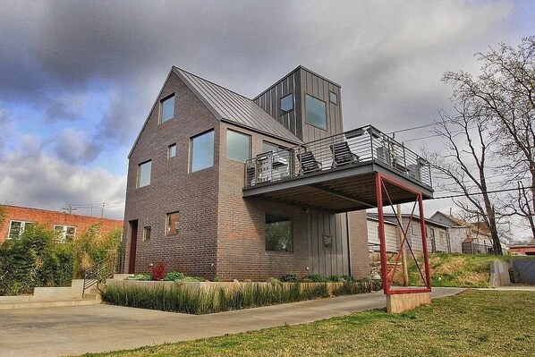 A modern two-story house with a balcony and a garage.