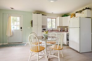 A kitchen with a dining table, chairs, a refrigerator, and cabinets. - Serene 1-bedroom cottage with AC in charming Thonotosassa (Thonotosassa)
