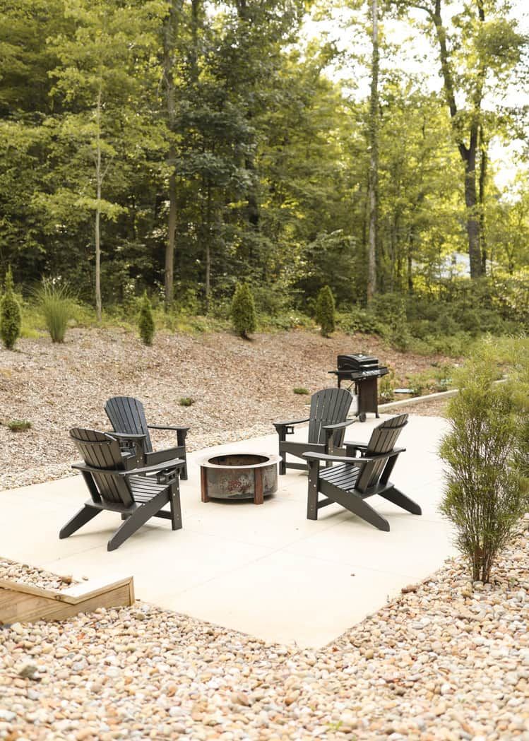 An outdoor seating area with Adirondack chairs and a fire pit.