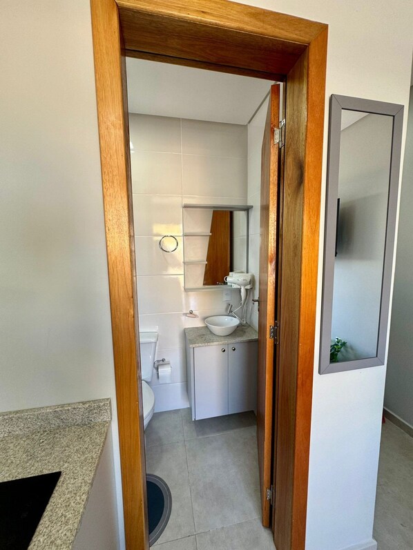 Une petite salle de bain comprenant des toilettes, un lavabo et un miroir.
