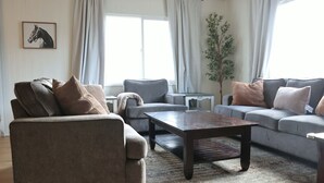 Una sala de estar con sofá, sillón y una mesa de centro.