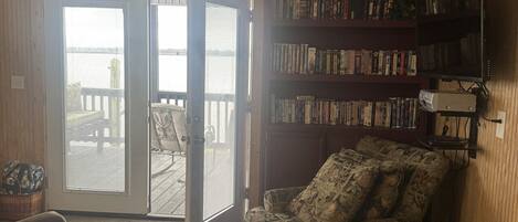 A living room with a sofa, a patterned armchair, a bookshelf, and a television.
