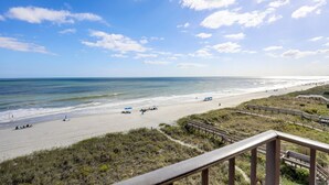 A beach with a wooden walkway and a view of the ocean. - Wake Up to Waves | Stunning Oceanfront Condo (North Myrtle Beach)