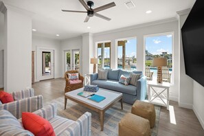 A spacious living room with a sofa, chairs, a coffee table, and a television. - New Beach Listing! Harmony Key - 8BR, 5Bath, Private Beach, Pool, Spa! (Pensacola)
