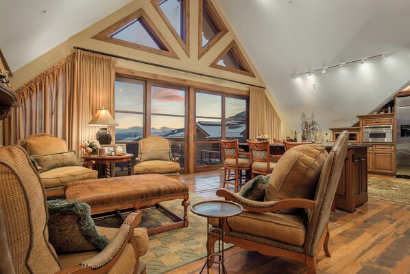 A spacious loft-style living area with high ceilings, large windows, and a view of the mountains. - Four Bedroom Penthouse in Teton Village (Teton Village)