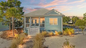 A single-story house with a porch, a small front yard, and a sandy path leading to the entrance. - Pet Friendly Beach House - Salt Therapy (Port St. Joe)