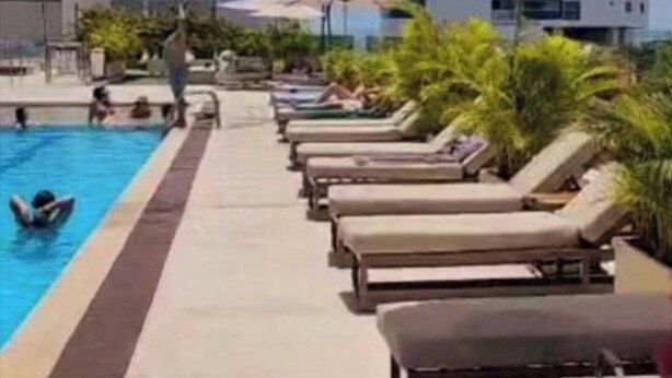 A rooftop pool area with lounge chairs and umbrellas, surrounded by tall buildings. - Ocean view Building with 1 bedroom and AC in peaceful Cartagena de Indias (Cartagena de Indias)